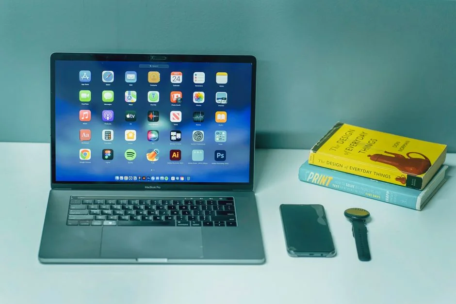 Un bureau de travail élégant mettant en avant des appareils Apple : iMac, MacBook et iPad.